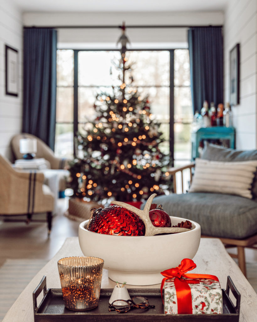 a Christmas tree out of focus with a coffee table in the foreground