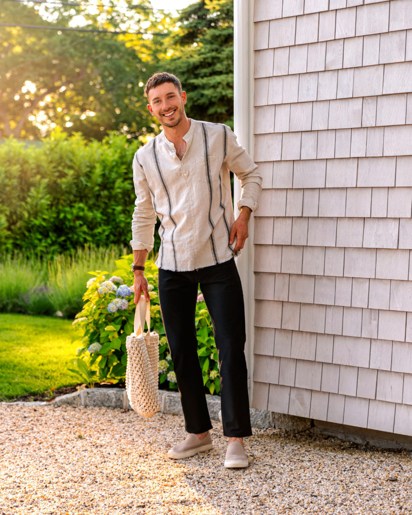 Man wearing linen shirt in front of shingle house