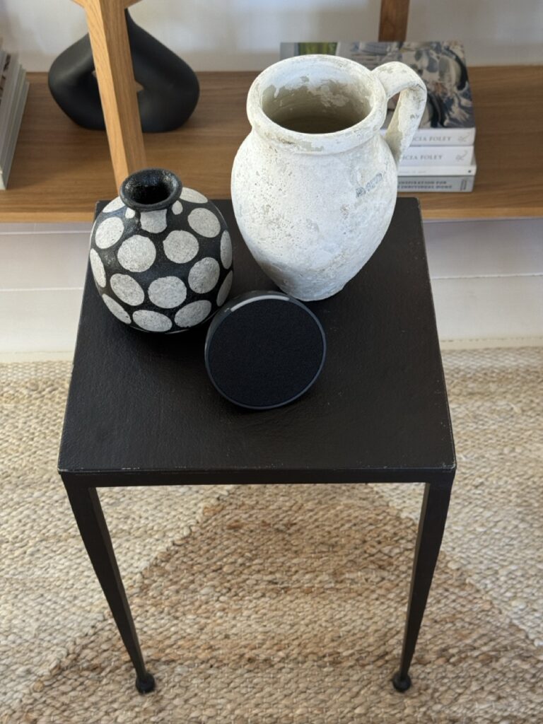 side table with smart speaker and modern rustic vases 